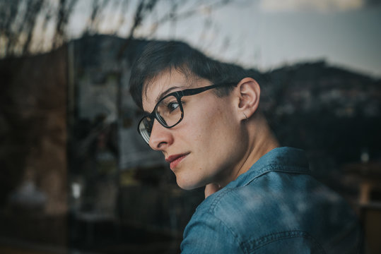 Chica mirando por la ventana con el t&eacute;