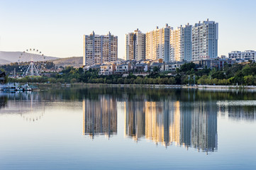 Plakat Residential buildings and ferris wheel water reflection in China