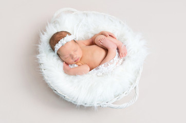 Child napping naked in a basket