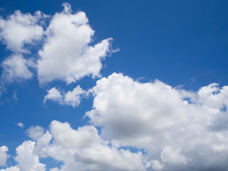 Vast blue sky background with white fluffy clouds