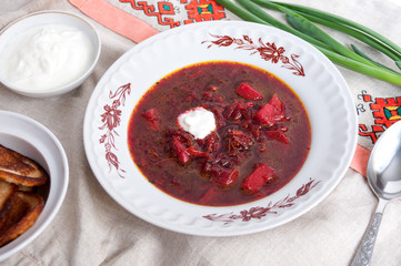 Ukrainian borsch made from beets with sour cream on table