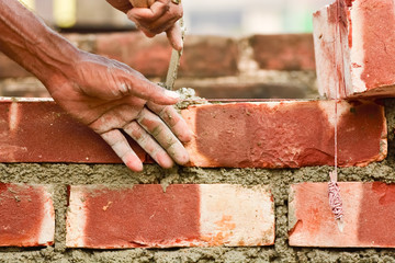 To build up a brick wall with trowel