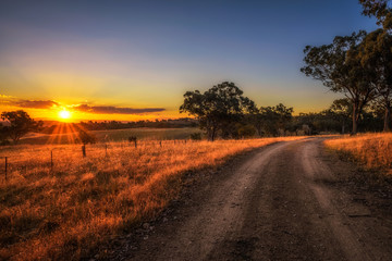 Countryside landscape with rural dirt road at sunset in Australia