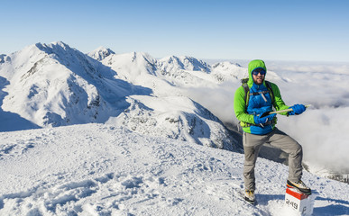 Mountaineer with ice axe and green blue jacket.