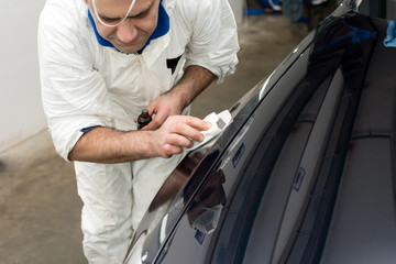 Man on a car wash polishing car with a polish machine