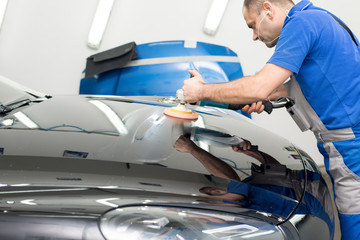 Man on a car wash polishing car with a polish machine