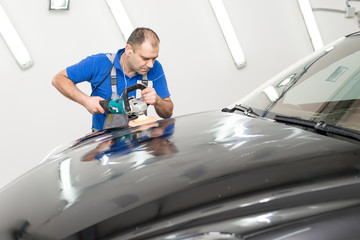 Man on a car wash polishing car with a polish machine