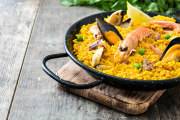 Traditional spanish seafood paella on wooden background
