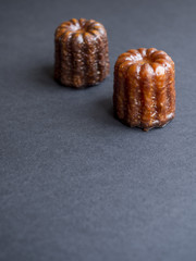 Canelés french pastry isolated on dark background