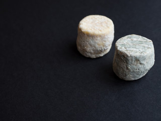 Two small dry cheeses isolated on black background