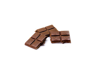 milk chocolate broken into pieces on a white isolated background