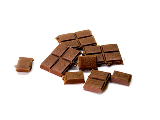 milk chocolate broken into pieces on a white isolated background