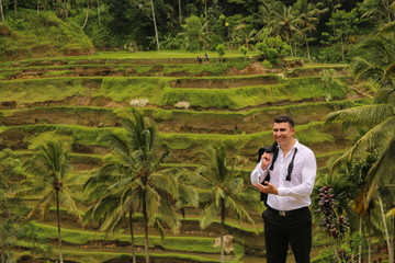 Handsome groom posing near rice field
