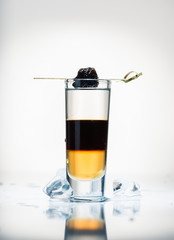 alcohol cocktail shot on a light background with reflection