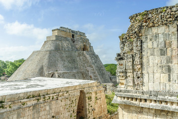 Fototapeta na wymiar sight of the pyramid of the magician and of several buildings of the quadrangle of the nuns in the Mayan archaeological Uxmal enclosure in Yucatan, Mexico