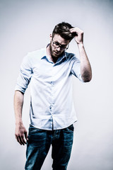  Jeune homme debout en chemise blanche, de face, une main dans les cheveux