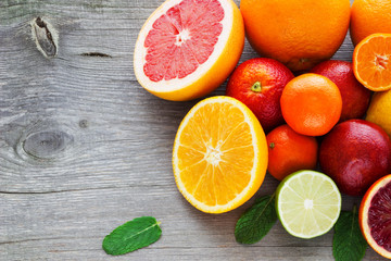 Naklejka na ściany i meble Lemon,red orange, orange, grapefruit, lime, tangerine on old wooden table. Place for text. Background.