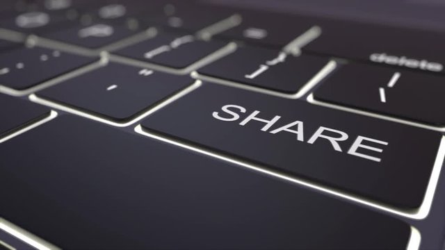 Tracking shot of modern black computer keyboard and luminous share key. Conceptual 4K clip