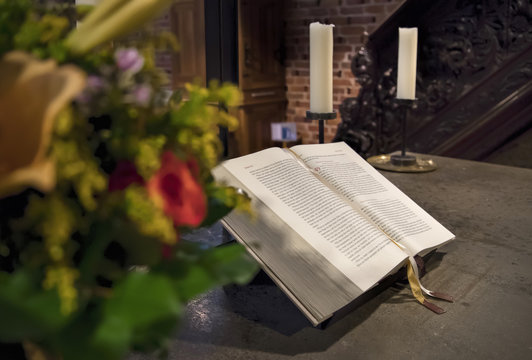 Heilige Bibel mit Blumenschmuck und Kerzen