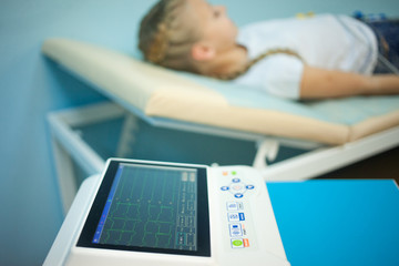 Electrocardiogram, cardiac cardiograph and conduct research in pediatrics, a girl doing an electrocardiogram