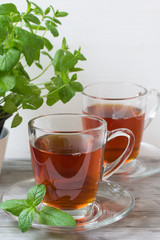 Black tea with mint. Grey wooden background.