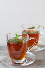 Black tea with mint. Grey wooden background.