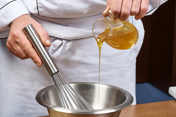 Close up of pouring honey from pitcher in jar