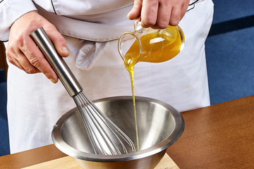 Close up of pouring honey from pitcher in jar