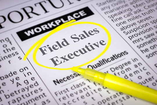 Field Sales Executive - Newspaper sheet with ads and job search, circled with yellow marker, Blurred image and selective focus