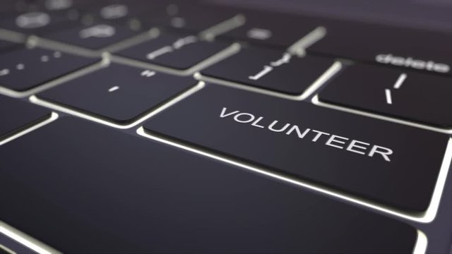 Tracking shot of modern black computer keyboard and luminous volunteer key. Conceptual 4K clip