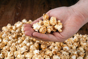 man holds a handful of popcorn in his hands