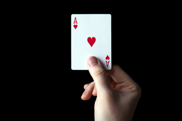 human hand holding the ace of hearts