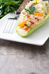 Stuffed zucchini with quinoa and vegetables on wooden background
