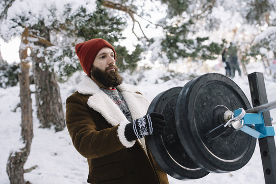 Man putting weigh plate to barbell