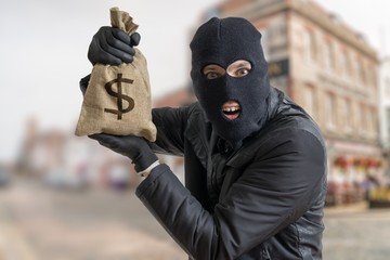 Happy robber is showing stolen bag full of money.
