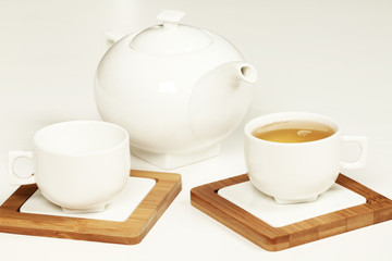 Hot tea in white cup and teapot