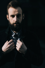 Portrait of a brutal bearded man on dark street background