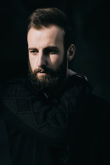 Portrait of a brutal bearded man on dark street background