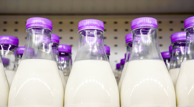 bottles with milk as dairy product for preparing breakfast wait for byers on market shelf