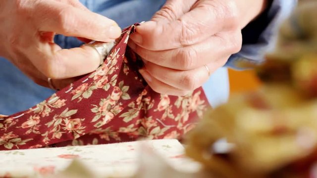 Closeup hands of seamstress at work with cloth fabric