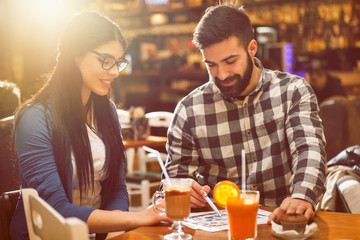 Couple looking at blue prints in cafe