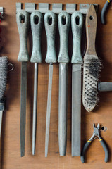 Old rasps hanged on the brown wooden board