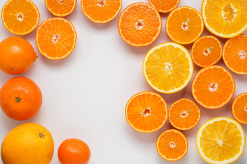 cut oranges and tangerines on a white background