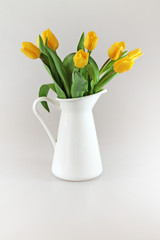 Bouquet of fresh yellow tulips in jug