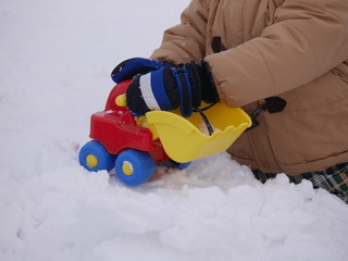 Obraz premium A child playing in snow with toys