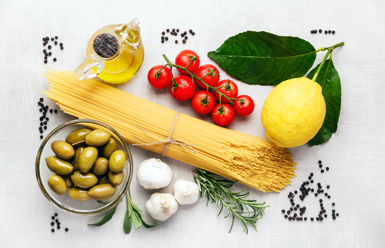 Spaghetti with ingredients for cooking pasta on a white background, top view. Flat lay