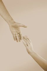Male and female hands on light background, toned in sepia