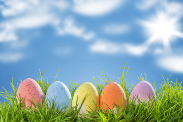 Easter eggs, on grass, blue sky background 