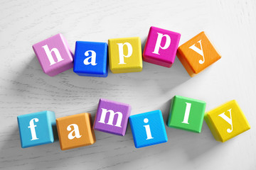 Colorful cubes with text HAPPY FAMILY on wooden background