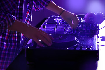 DJ mixing tracks on a mixer in a nightclub